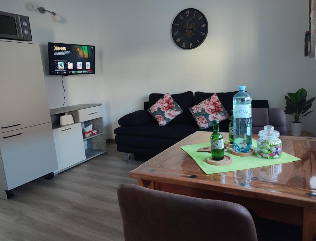 a living room with a table with two bottles on it at Be Home! Apartment Gratkorn in Gratkorn