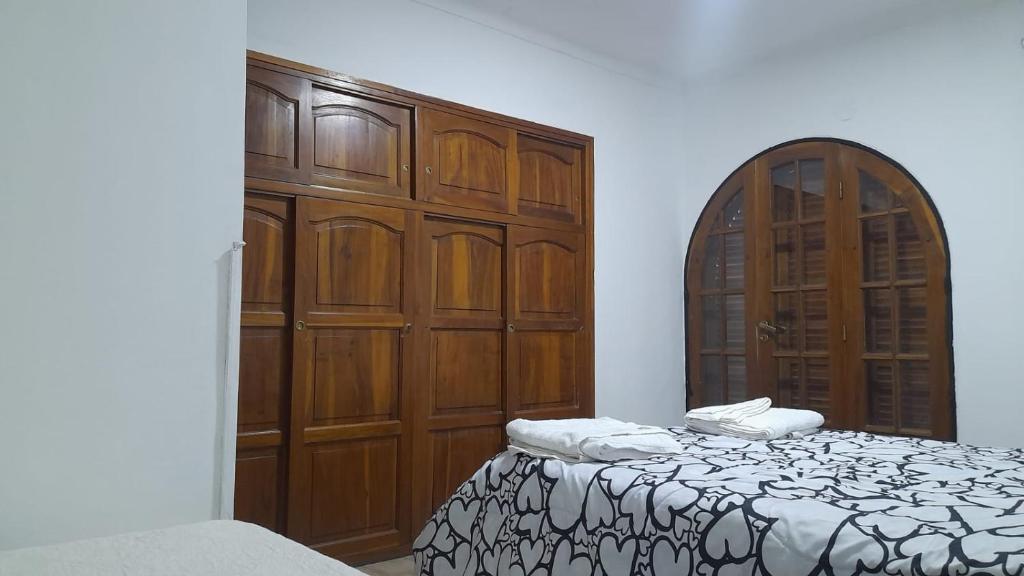 een slaapkamer met houten kasten en een bed bij Departamento Brasil in Lunlunta