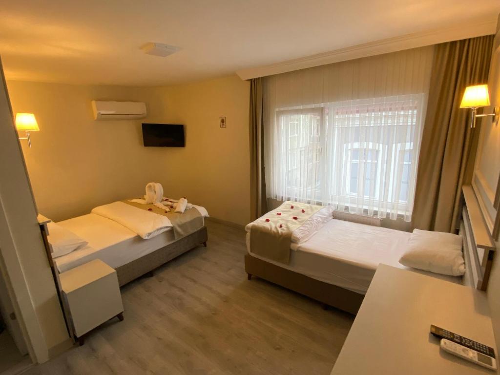 a hotel room with two beds and a window at GRANDAURA EDıRNE in Edirne