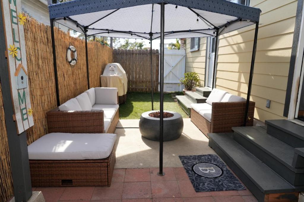 an outdoor patio with chairs and an umbrella at Surf city House in Huntington Beach