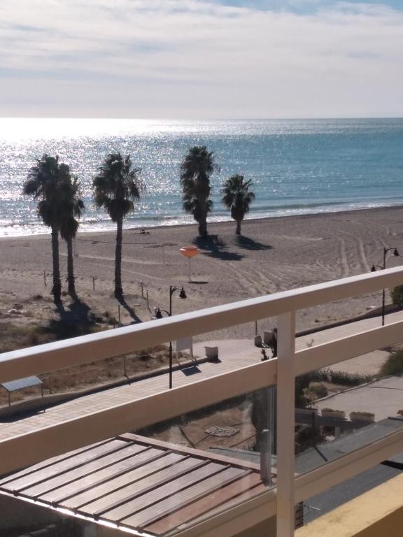vistas a una playa con palmeras y al océano en Atico Duplex 1ª, en Xilxes