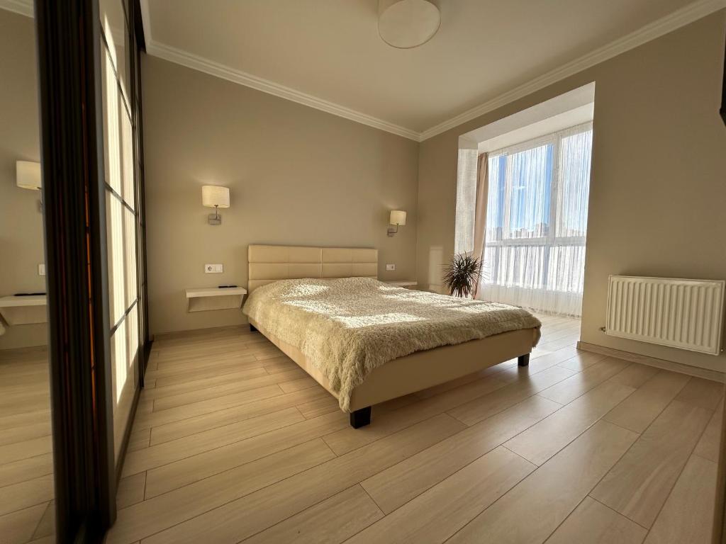 a bedroom with a bed and a large window at Kalinova Sloboda Home in Ivano-Frankivsʼk