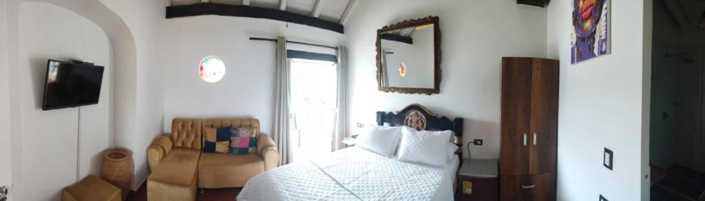 una camera con un letto bianco e una sedia di EMMA HOTEL SAN DIEGO a Cartagena de Indias