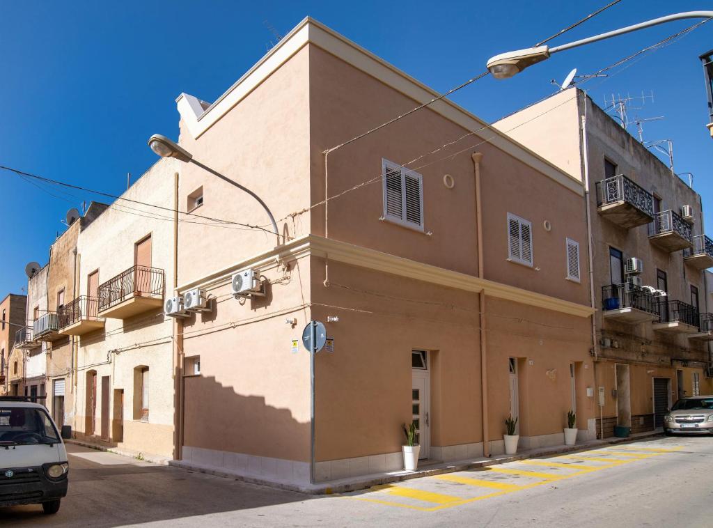 un edificio marrone su una strada con auto parcheggiate di fronte di Casa Vacanze GeO a Mazara del Vallo