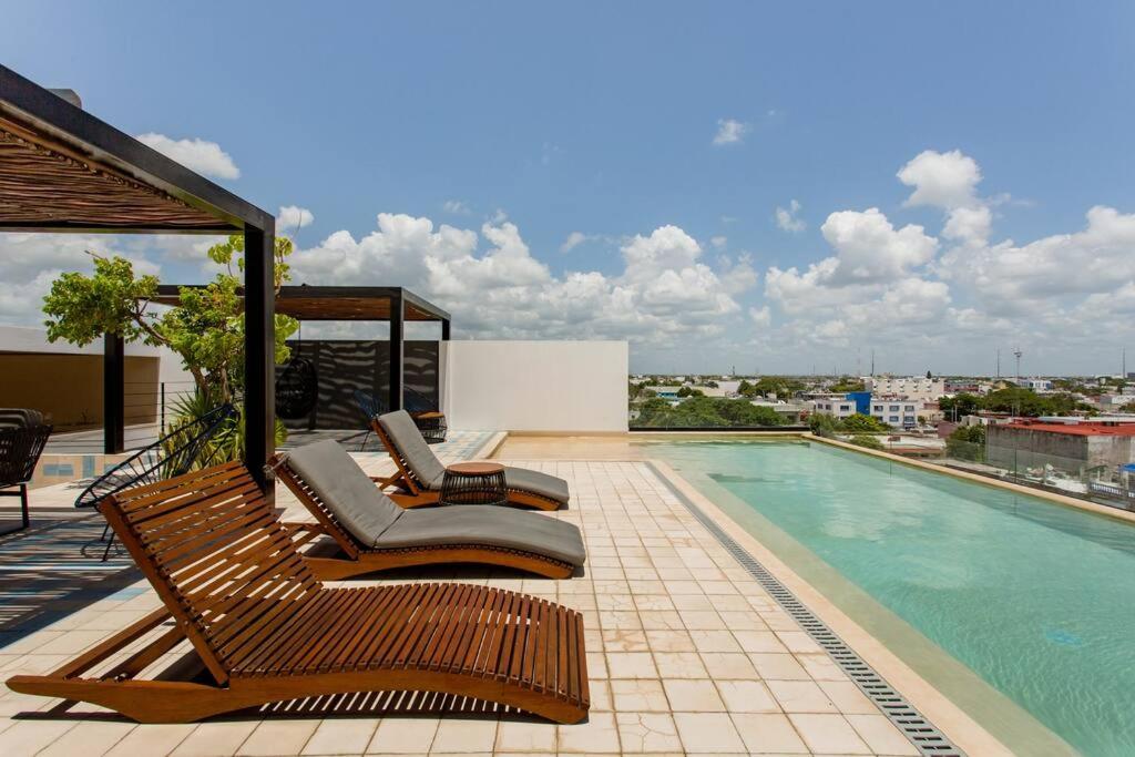 a swimming pool with chaise lounge chairs on a balcony at Riva Condos by The Spot Rentals in Playa del Carmen