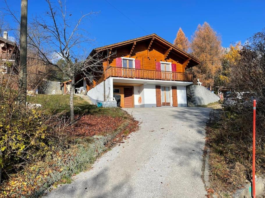 ein Haus mit Balkon an der Straßenseite in der Unterkunft Chalet le Domino - Proche des pistes et des bains in Ovronnaz