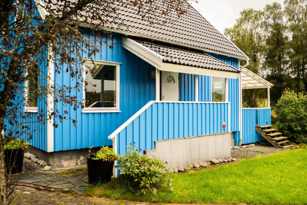 una casa blu con una porta bianca di Landvetter Hotell a Härryda