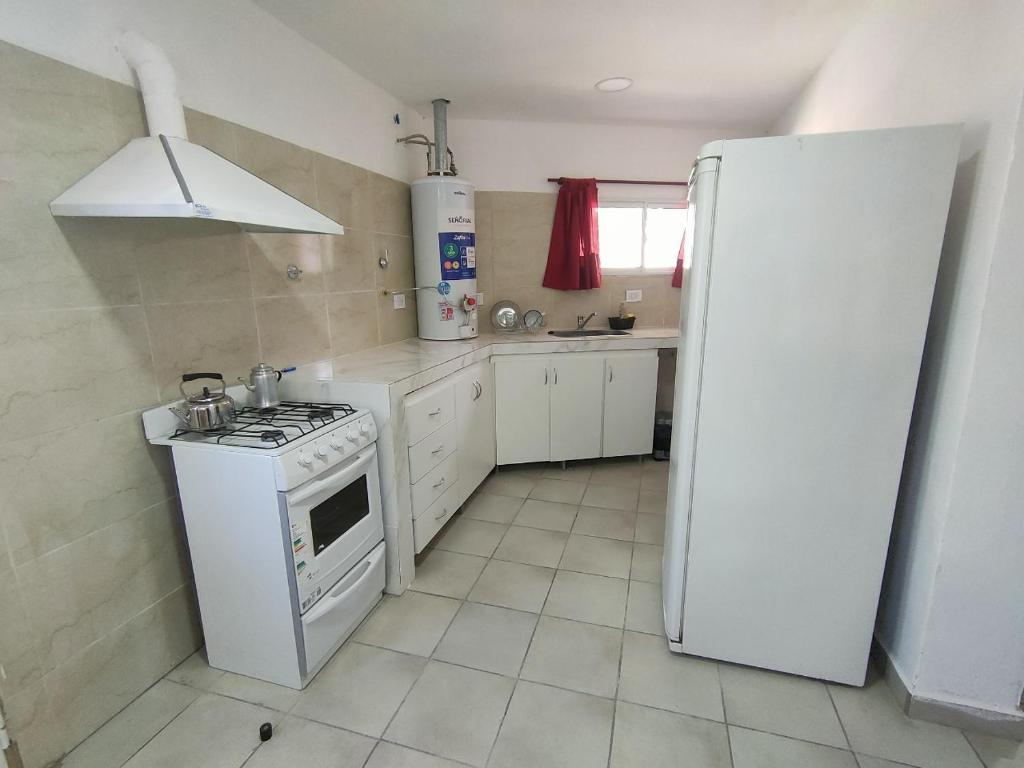 una cucina con piano cottura bianco e frigorifero di Departamento San Luis 320 a General Roca