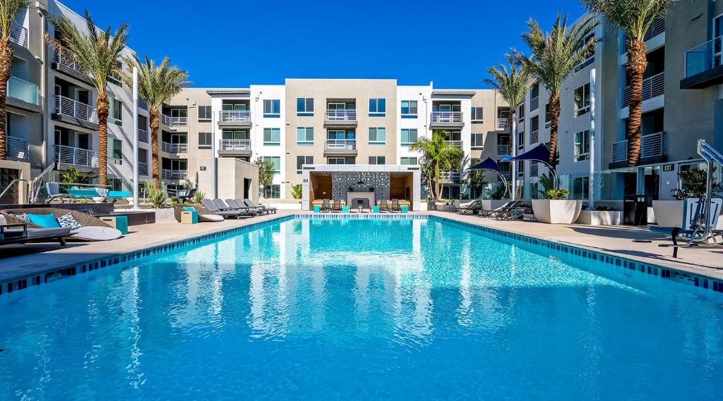 uma grande piscina com palmeiras e edifícios em Global Luxury Suites Irvine em Irvine