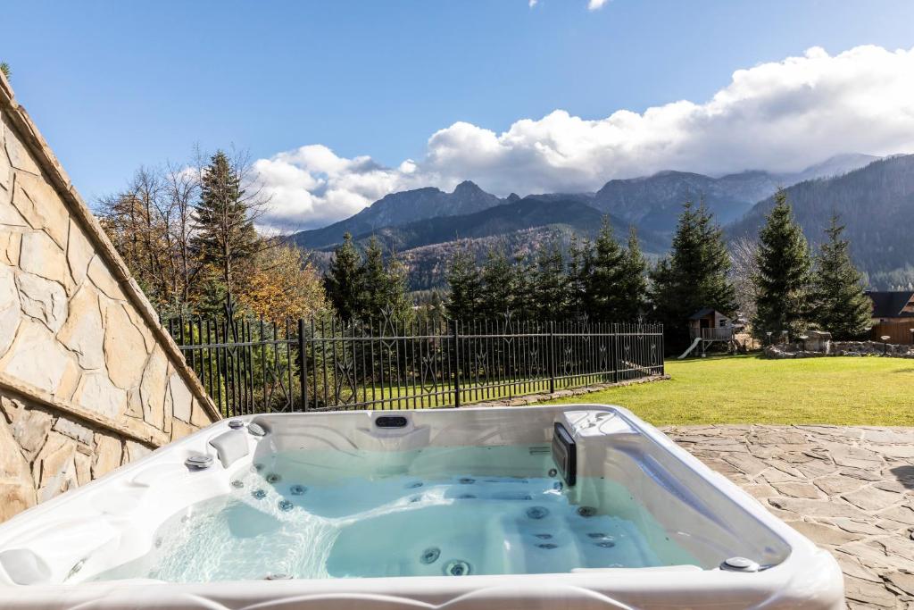 a jacuzzi tub with a view of the mountains at Mountain Base - Rezydencja Górski Potok Premium in Kościelisko