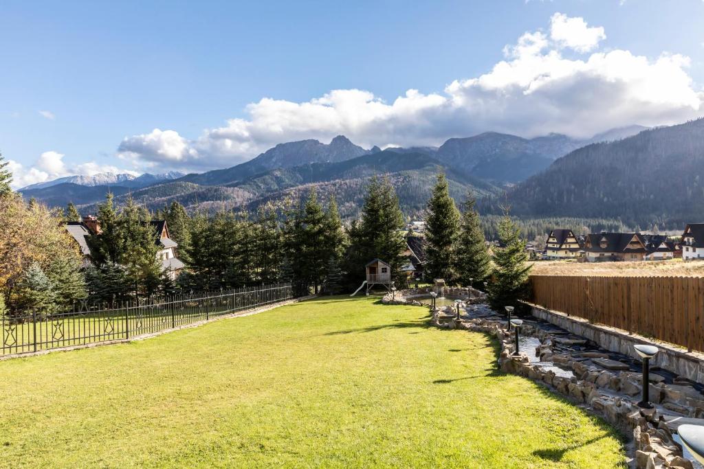 a large yard with mountains in the background at Mountain Base - Rezydencja Górski Potok Premium in Kościelisko