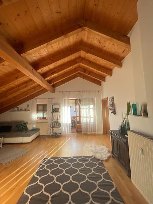 una gran sala de estar con techos de madera y una alfombra. en Zweite Heimat in Mühldorf en Mühldorf