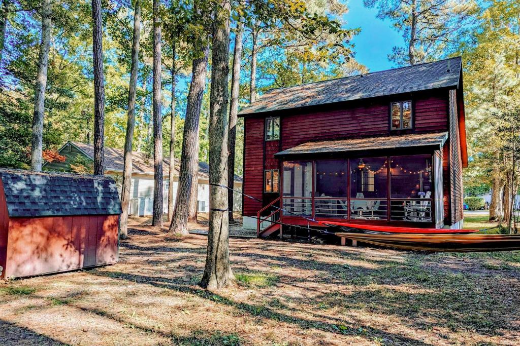 a log cabin in the woods with a tree at The Red House at the Beach in Ocean Pines