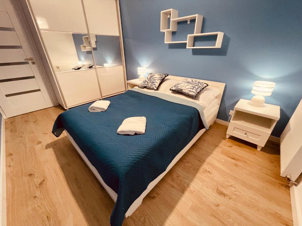 a bedroom with a bed and a large mirror at Apartamenty KTW Park Śląski Bytkowska 103A in Katowice