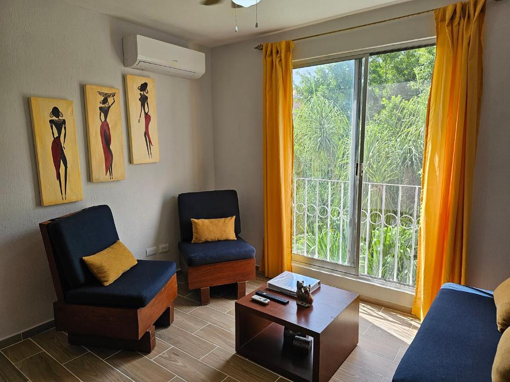 a living room with two chairs and a window at Amplio Departamento in Cancún