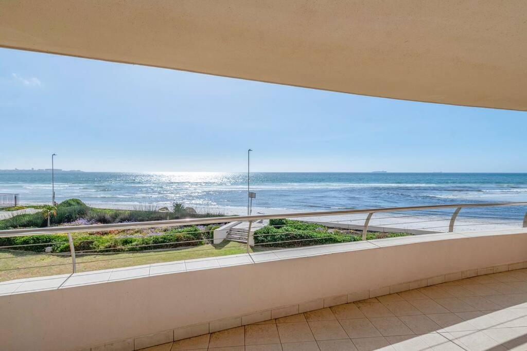 a balcony with a view of the ocean at Oceanfront Residence in Lagoon Beach in Cape Town