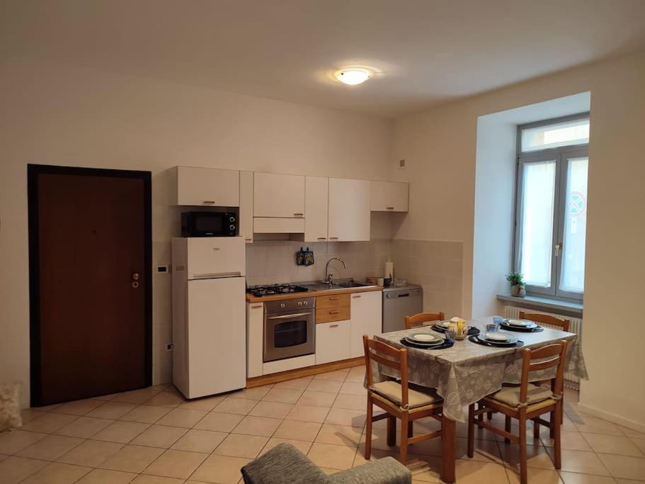 una cucina con tavolo e frigorifero bianco di Mi'Ele Apartments a Pergine Valsugana