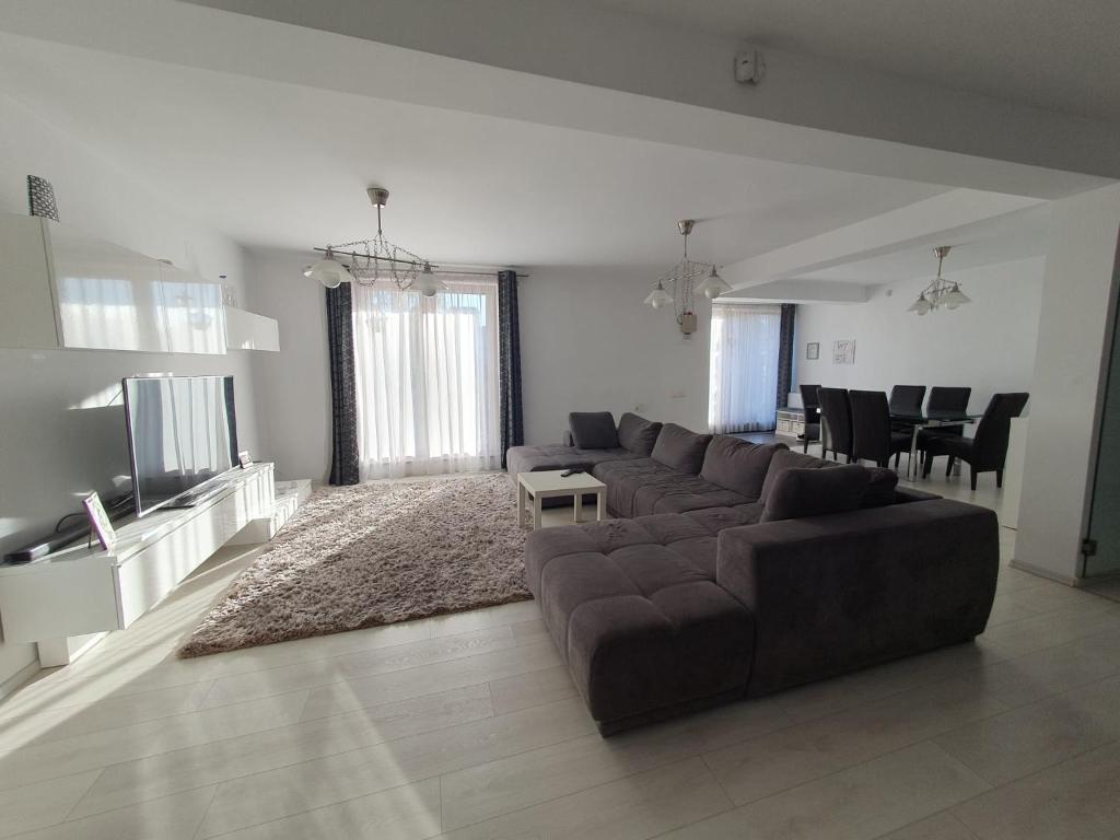 ein großes Wohnzimmer mit einem Sofa und einem Tisch in der Unterkunft Vila Vati - Arena Pitesti in Piteşti