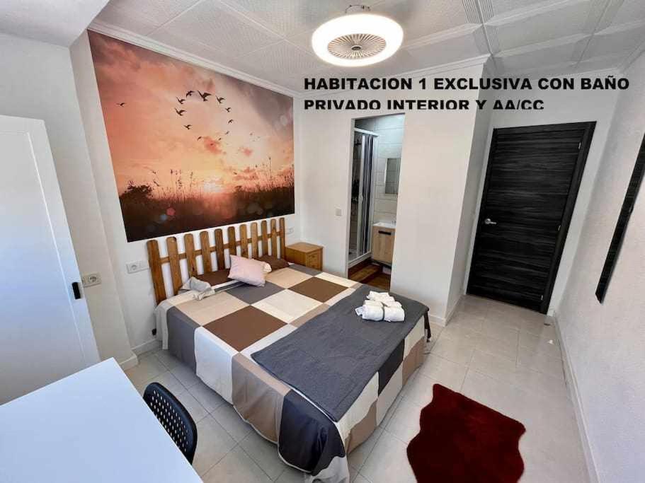 Schlafzimmer mit einem Bett mit Wandgemälde in der Unterkunft Novelda Centro Habitaciones con baño privado y compartido , cocina y terraza in Novelda