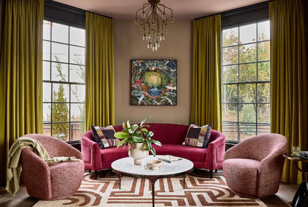 a living room with two red chairs and a table at Zelda Dearest in Asheville