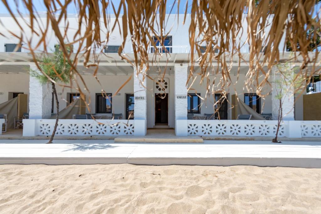 a building with a beach in front of it at Emily Hotel in Vári