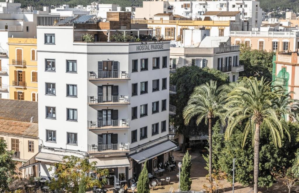 um edifício branco numa cidade com palmeiras em Hostal Parque Ibiza em Ibiza