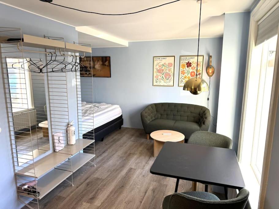 een woonkamer met een bank, een tafel en een bed bij Central studio apartment in Reykjavík
