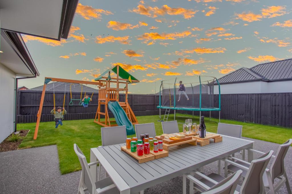 a patio with a table and a playground at New Luxury Home with Games Room and Park Outlook Sleeps 12, 26 mins from CHC airport in Lincoln