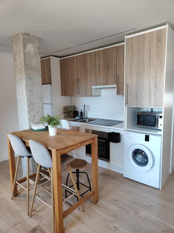 a kitchen with a wooden table and white appliances at Apartamento Elvira in Granada