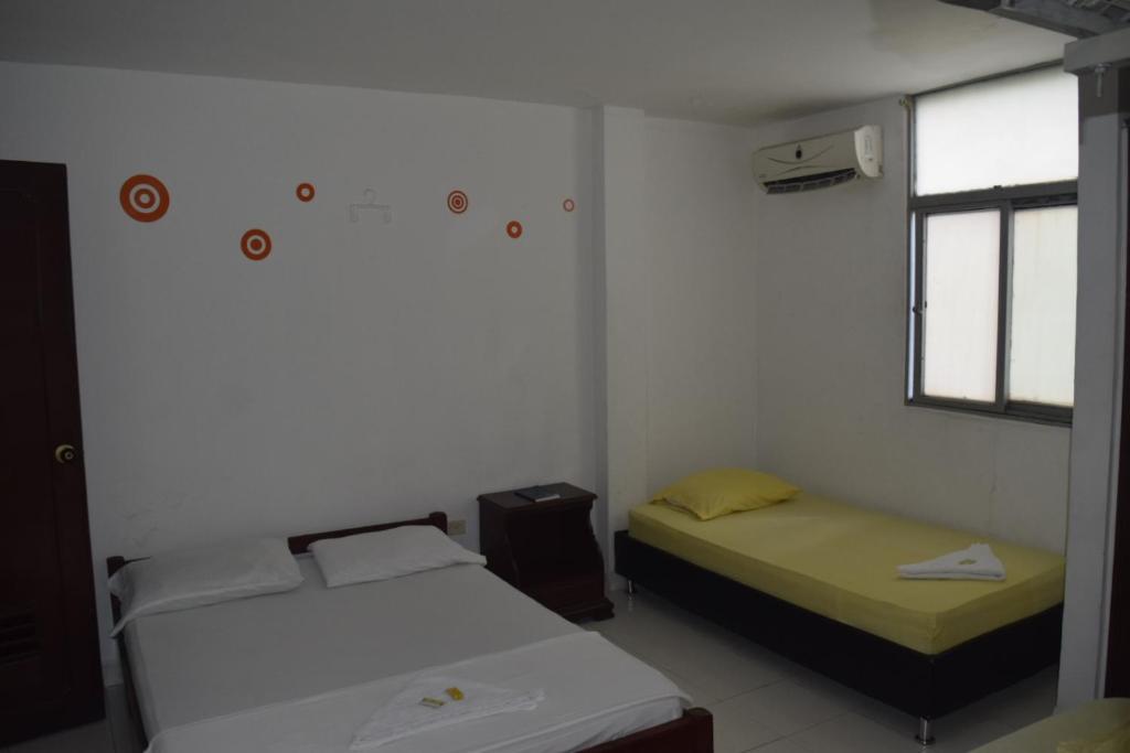 two beds in a small room with a window at Gran Hotel Caravana in Cúcuta