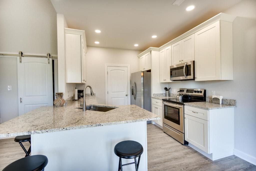 a kitchen with white cabinets and granite counter tops at Cape Charles Home 4 Mi to Kiptopeke State Park! in Cape Charles