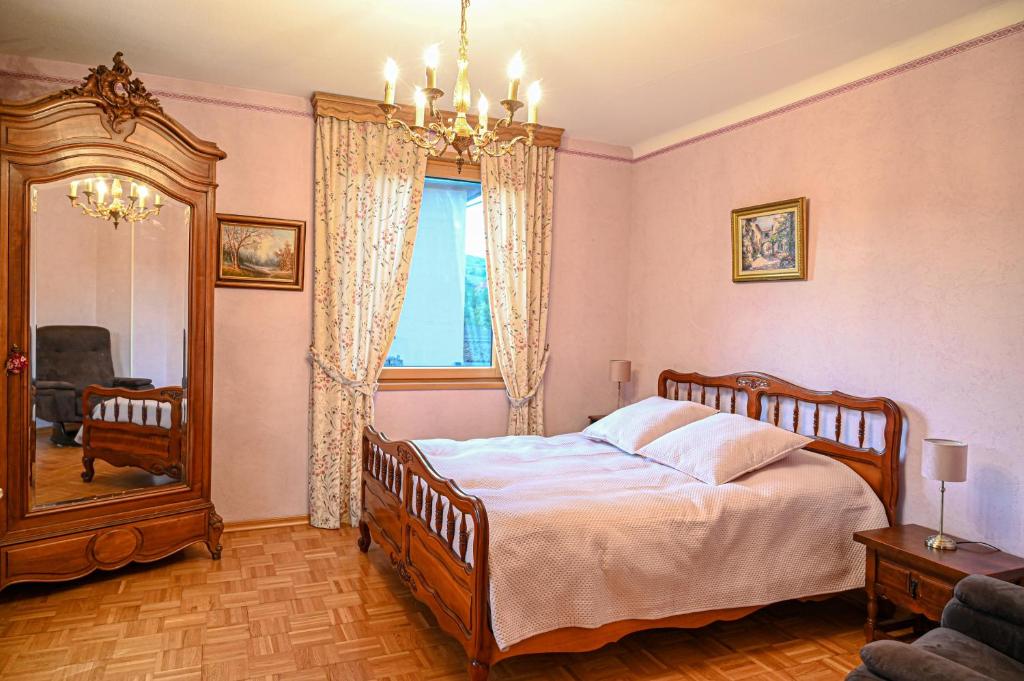 1 dormitorio con 1 cama grande y espejo en Gîte l'Avant, en Rouffach