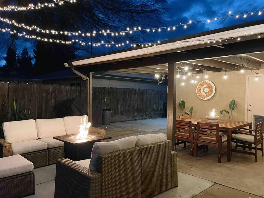 un patio con mesa, sillas y luces en Cozy Home w/Tesla Charger & Near National Parks, en Sanger