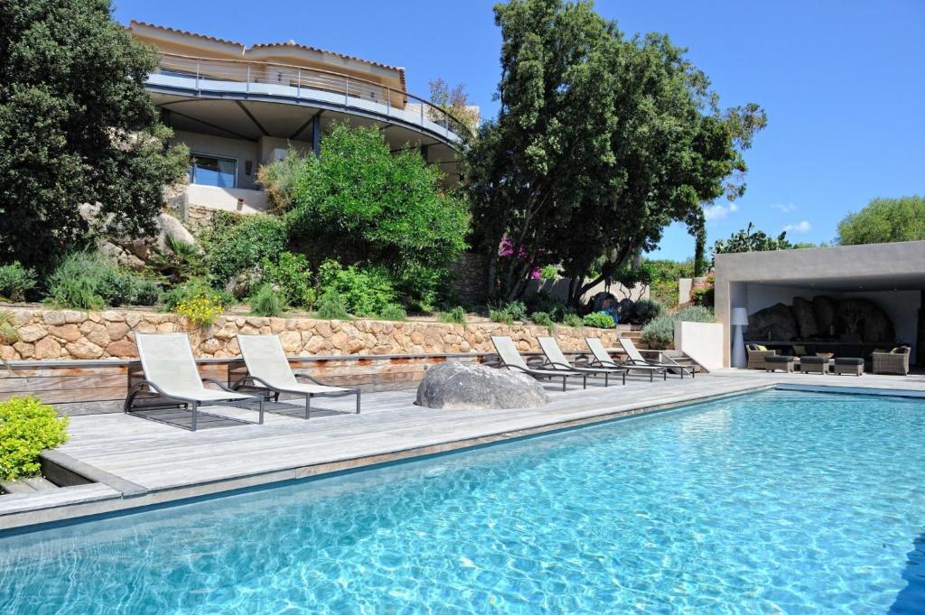 a pool with lounge chairs next to a building at Marina di cavu in Bonifacio