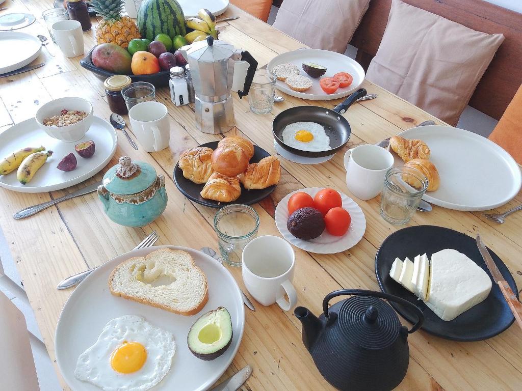 una mesa de madera cubierta con platos de desayuno en Casita de Piedra, en Bogotá