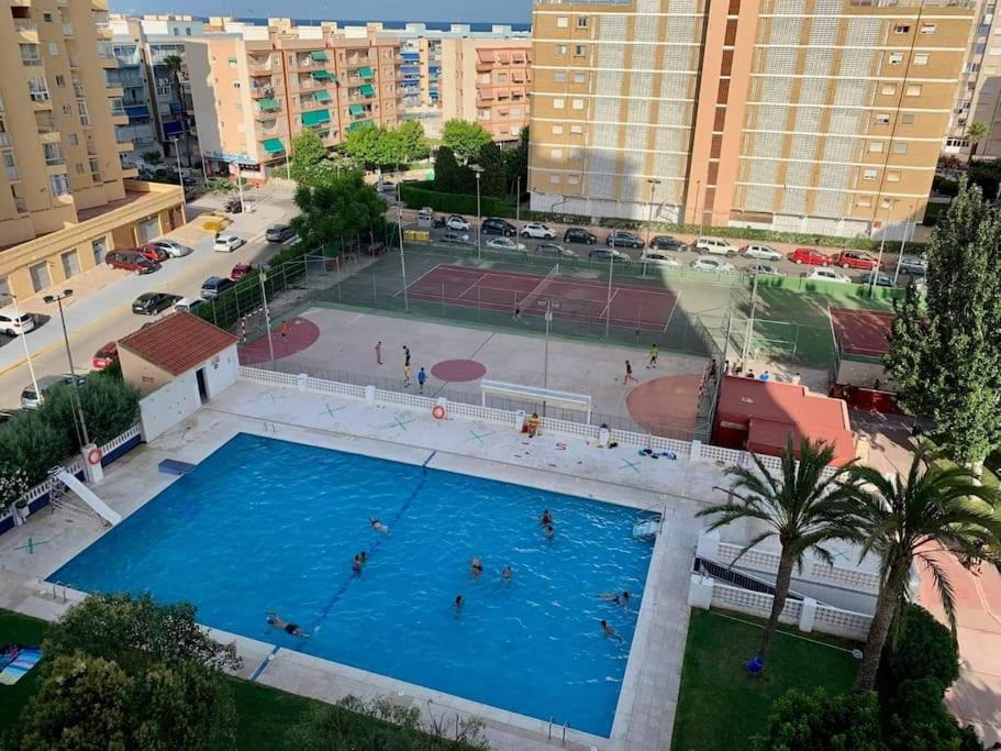 an overhead view of a pool with people playing tennis at Amplio apartamento in Puebla de Farnals