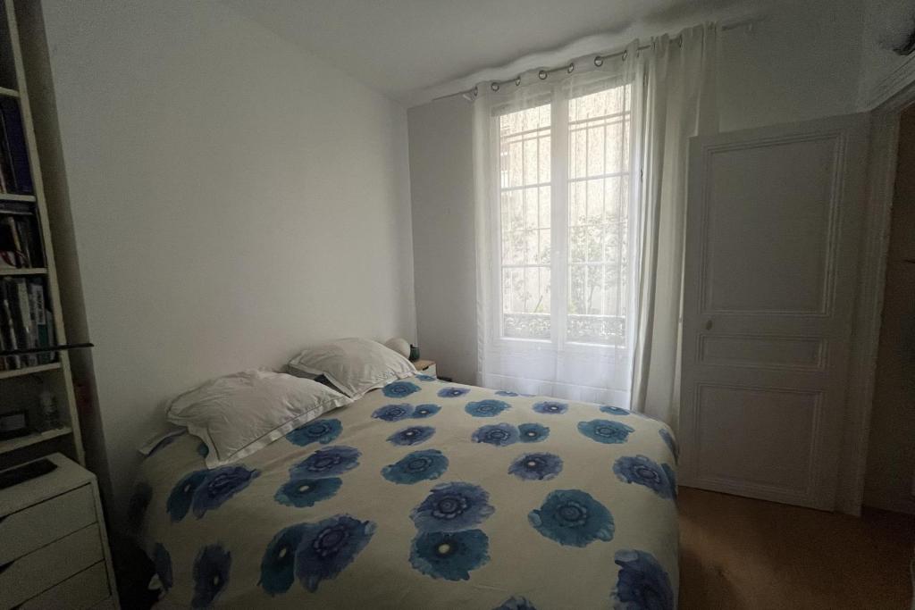a bedroom with a bed with blue flowers on it at Charming apartment in the heart of Paris in Paris