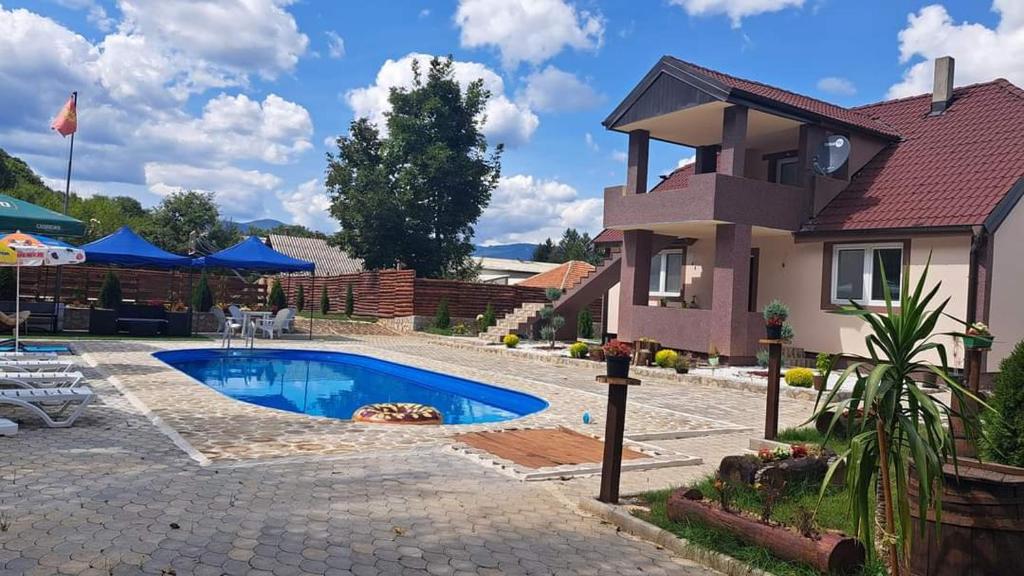 a villa with a swimming pool in front of a house at Vila Bate Bole 