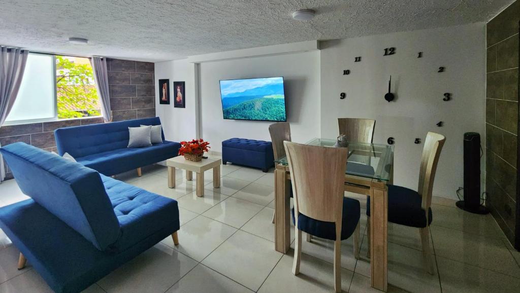 a living room with blue couches and a dining table at Apartamento en el Peñón - Oeste in Cali