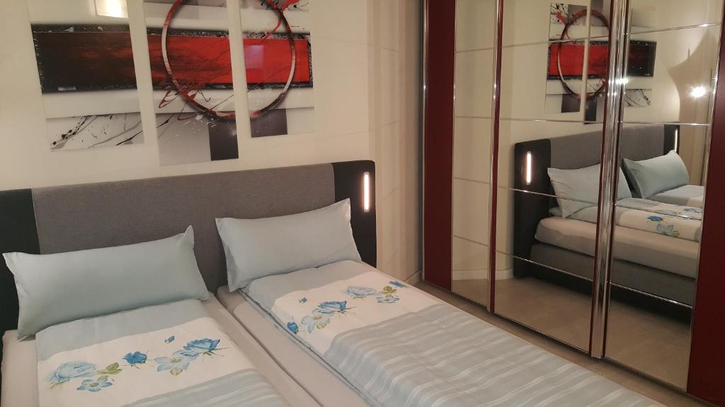 1 dormitorio con 2 camas y espejo en Appartement in Düsseldorf Nähe Messe Flughafen en Düsseldorf