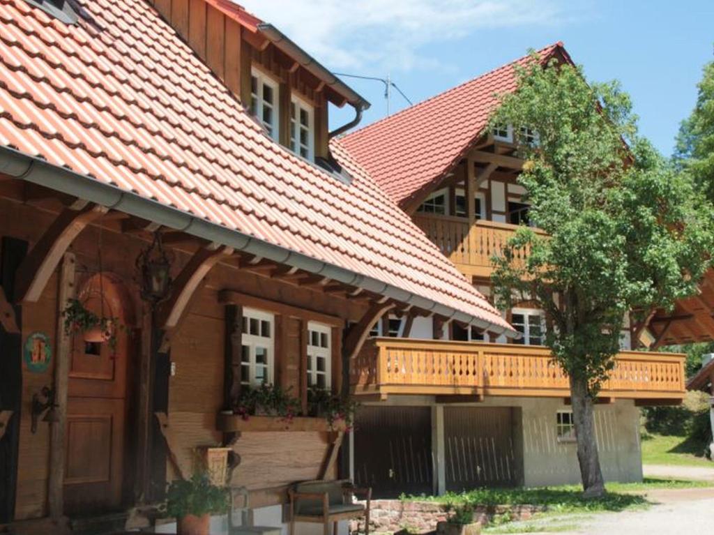 ein großes Holzhaus mit einer Terrasse darauf in der Unterkunft Ferienhof Männle in Gengenbach