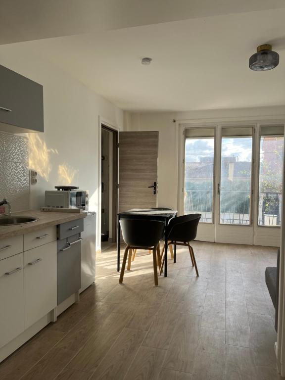 cocina con mesa y sillas en una habitación en Appartements proches CDG Le Bourget dans maison francilienne typique, en Le Blanc-Mesnil
