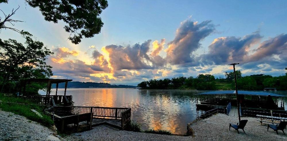 a view of a lake with benches and a dock at Lakeshore Cabin 5 on the Lake in Lake Ozark