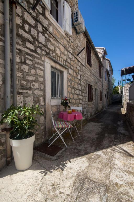 a table and chairs sitting outside of a building at Apartments Lotti 2 in Stari Grad