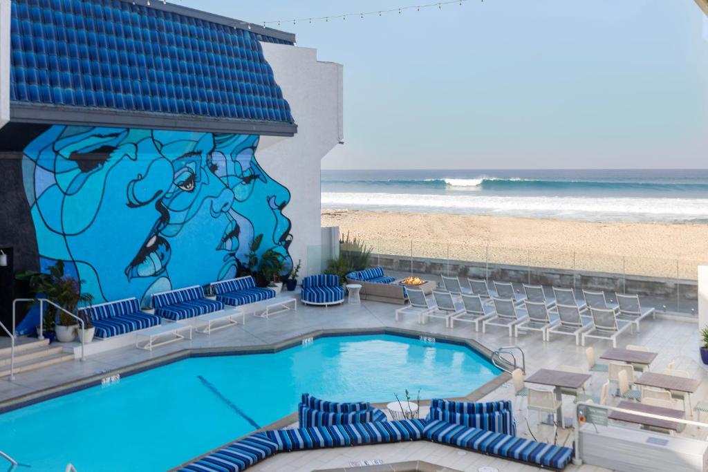 a swimming pool with chairs and the beach at The Wayfarer San Diego in San Diego