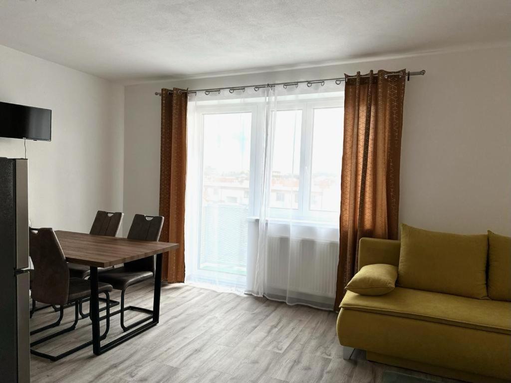 uma sala de estar com uma mesa e um sofá em Sky Apartments 512 em Plzeň