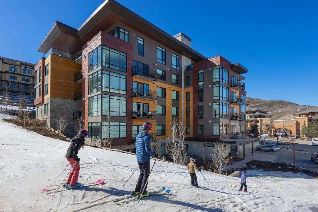 eine Gruppe von Personen auf Skiern vor einem Gebäude in der Unterkunft Lift by All Seasons Resort Lodging in Park City