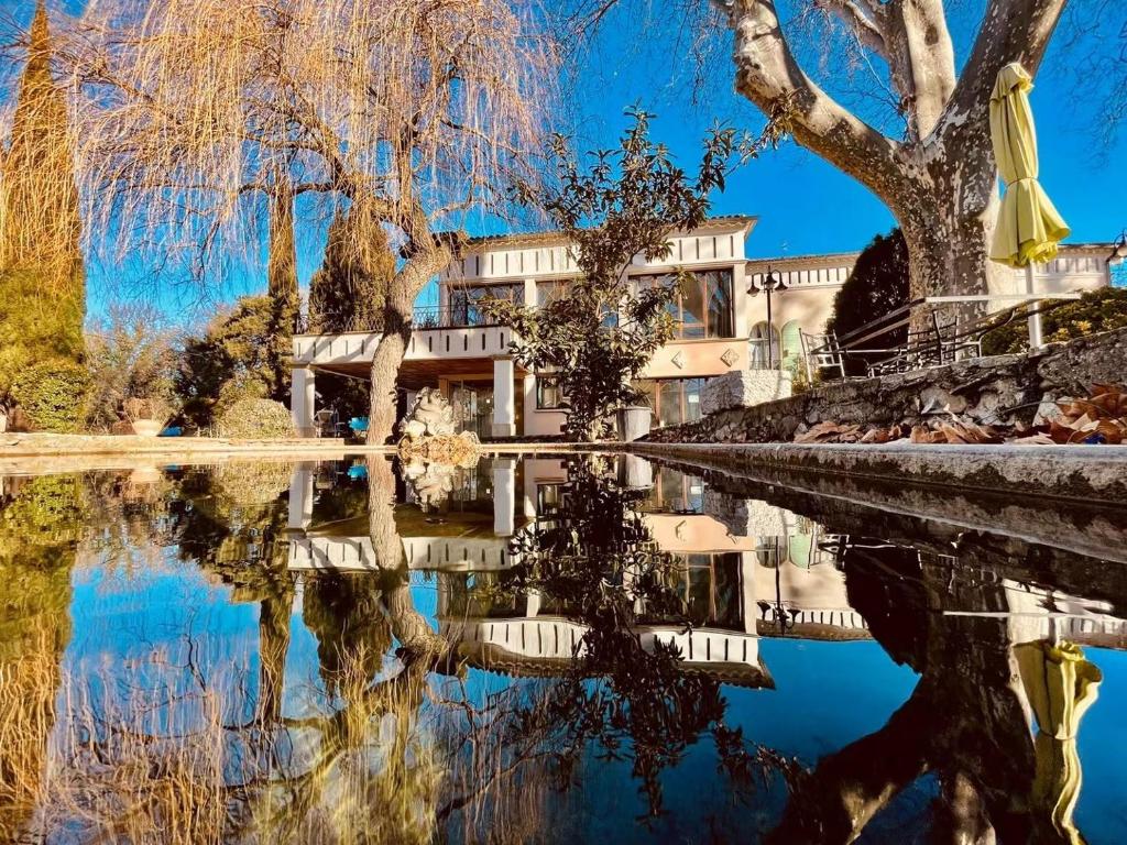 un edificio junto a una masa de agua en Hôtel La fuste en Valensole