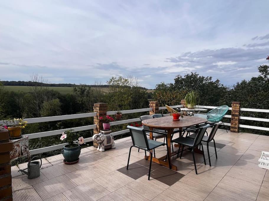 un patio avec une table et des chaises sur une terrasse dans l'établissement Chez Karine et Fred, à Airion