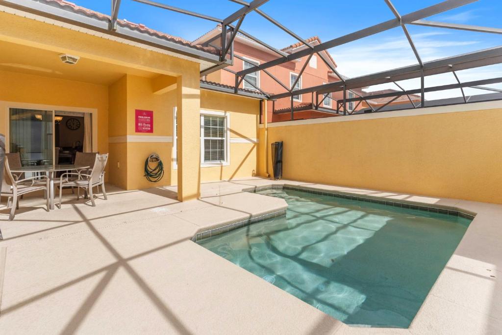 a swimming pool on a patio with a table and chairs at 8960 Cat Palm Road in Kissimmee